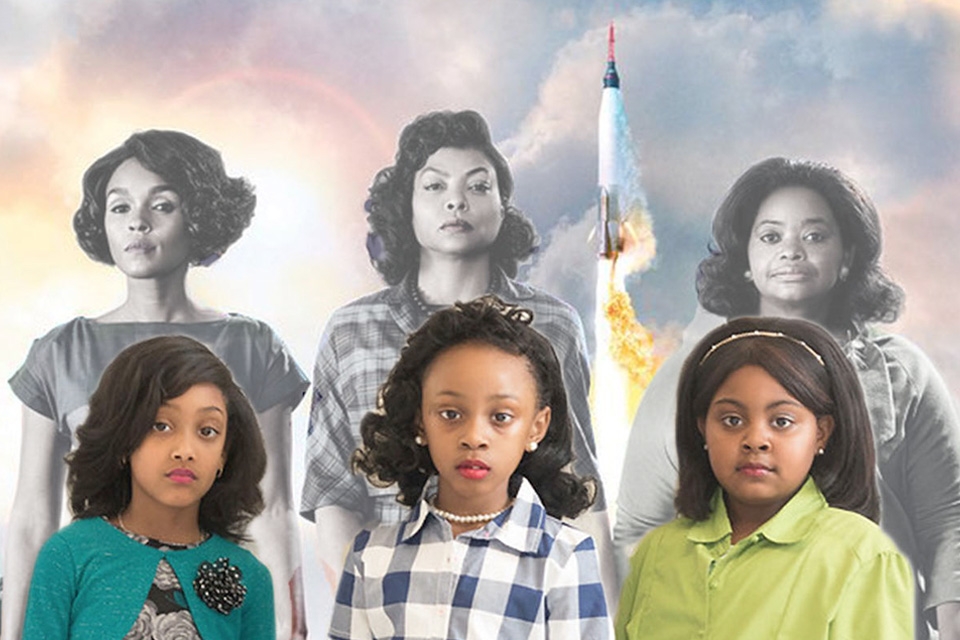 Meninas vestidas como as personagens de Estrelas Além do Tempo posando em frente ao poster do filme. 